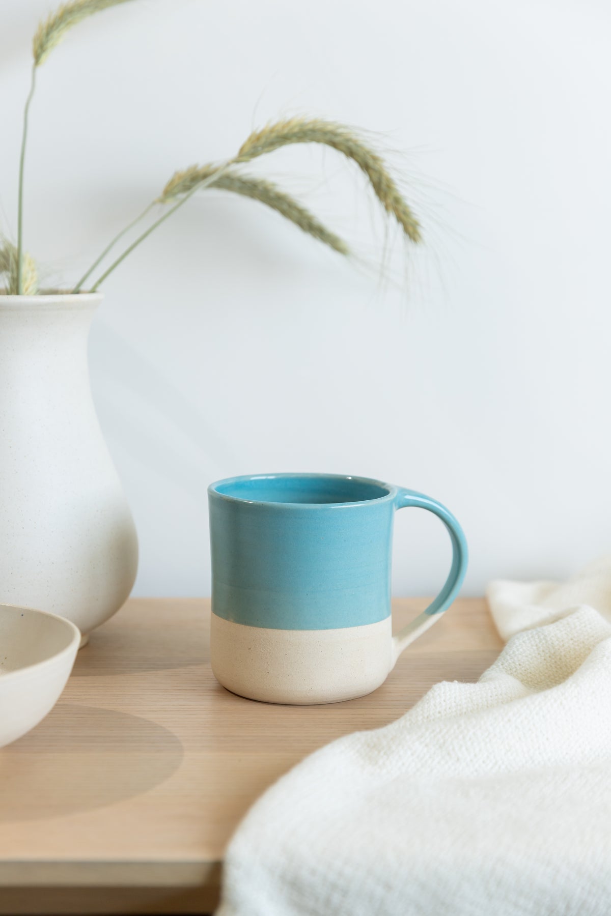 Blue mug on a wooden surface with a white background