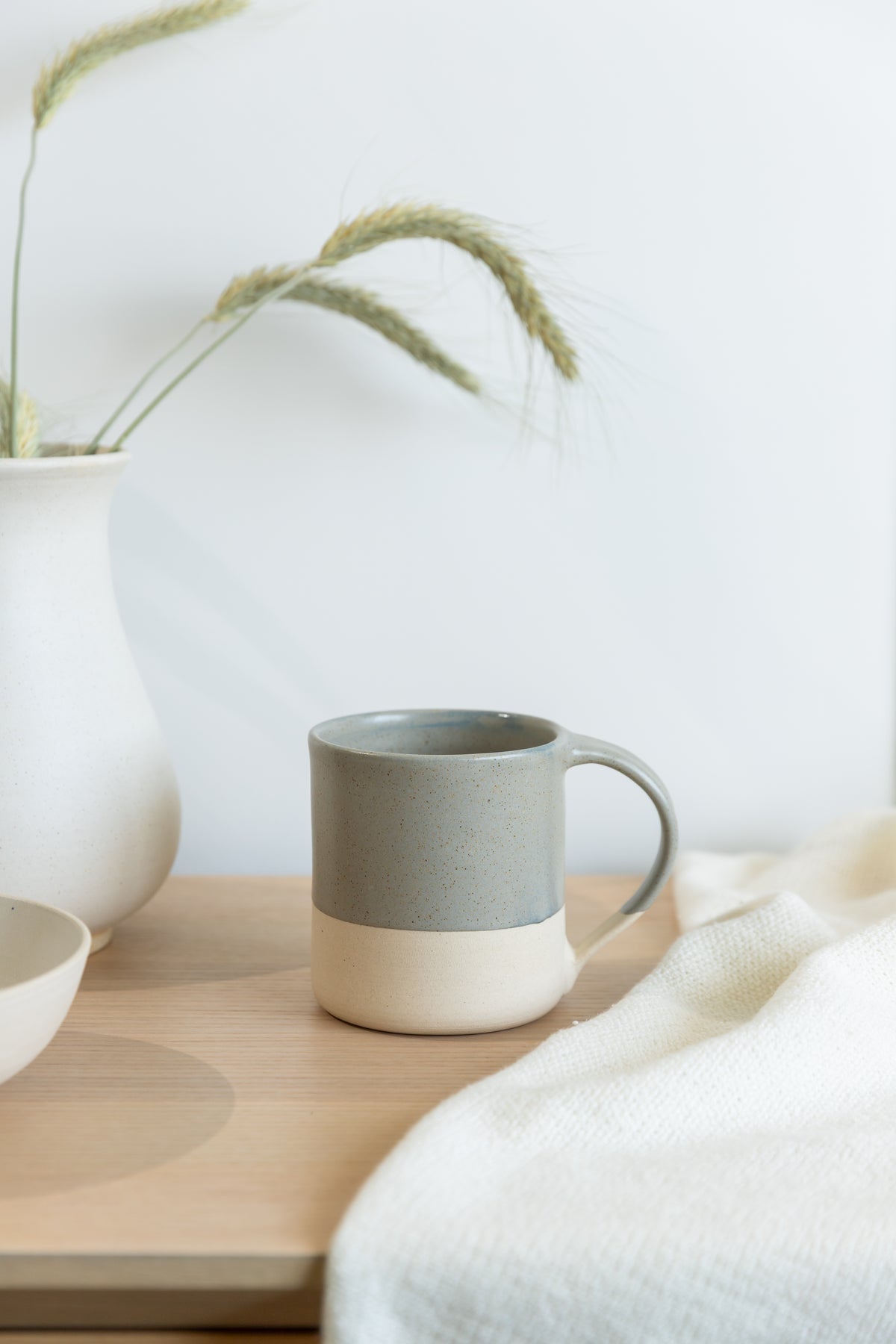 Gray mug on a wooden surface with a white background