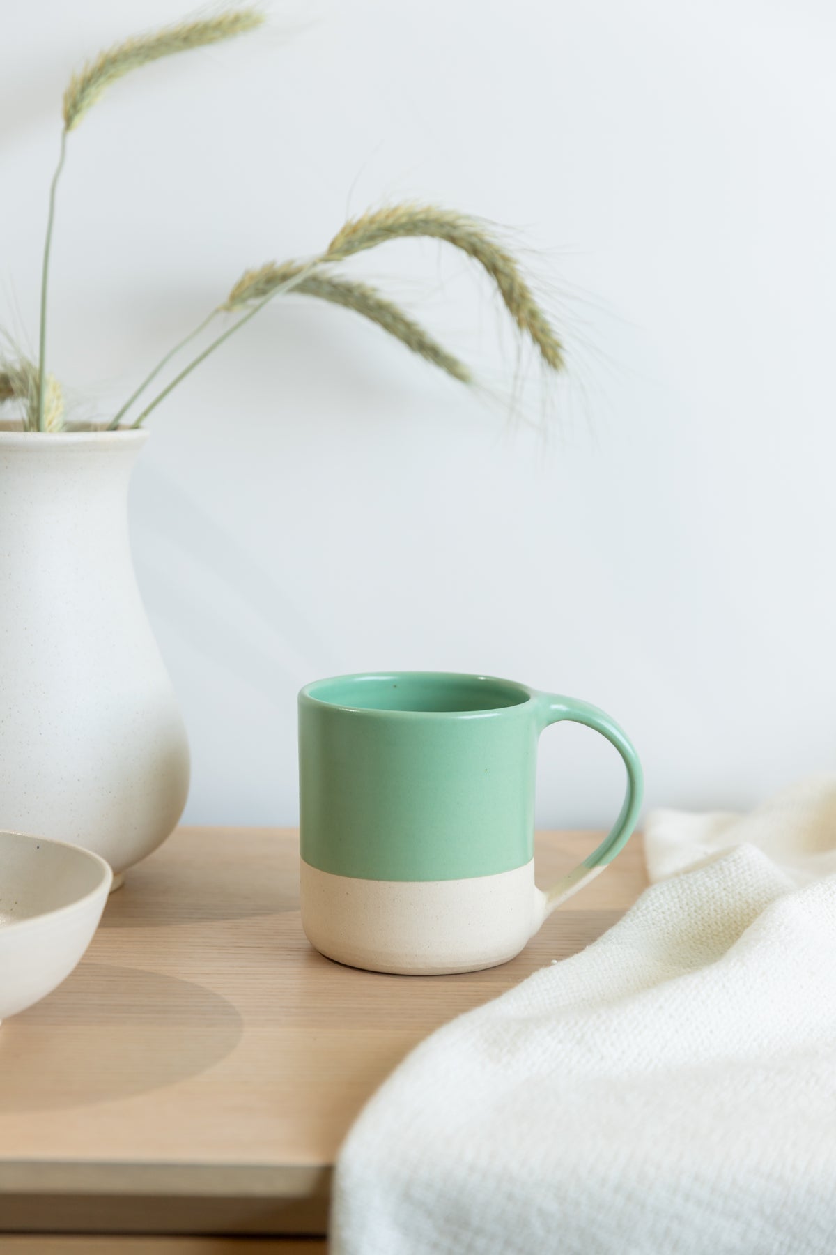Green mug on a wooden surface with a white background